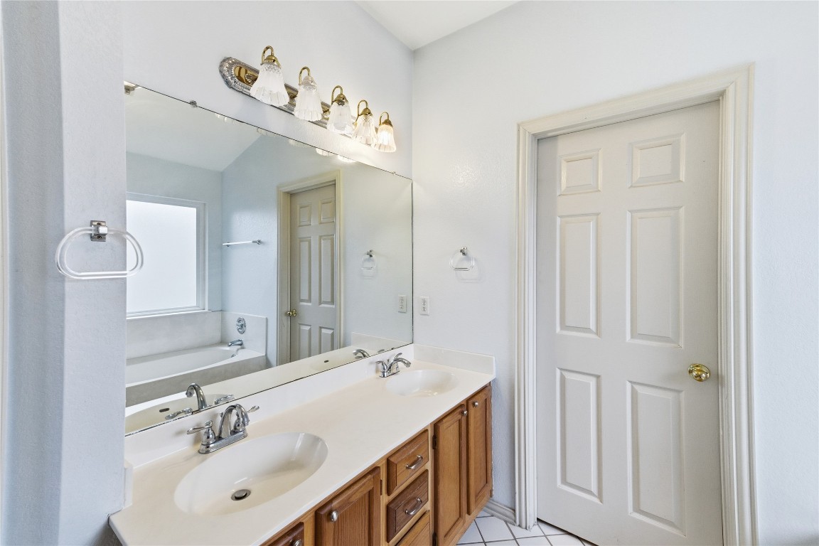 910 Kirtomy Loop Pflugerville, TX 78660 - Photo 30 of 37 a bathroom with a double vanity sink and a mirror
