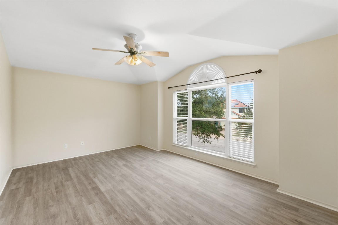 910 Kirtomy Loop Pflugerville, TX 78660 - Photo 31 of 37 an empty room with wooden floor fan and windows