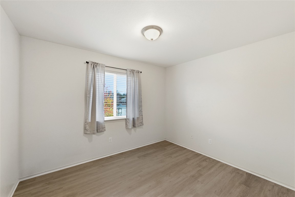 910 Kirtomy Loop Pflugerville, TX 78660 - Photo 7 of 37 an empty room with wooden floor and windows