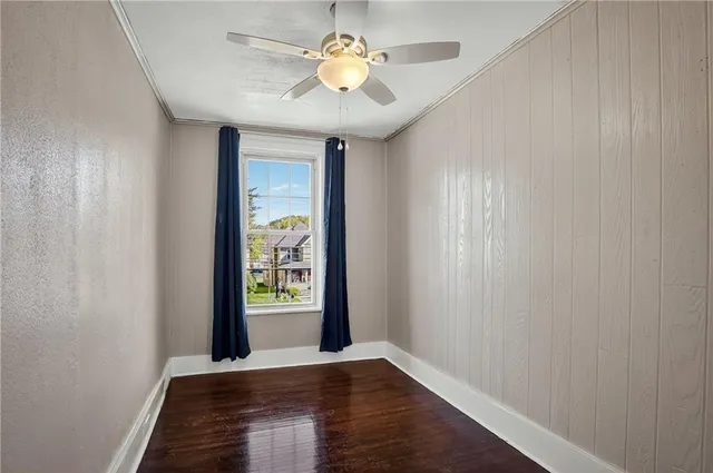 a view of an empty room with window and wooden floor