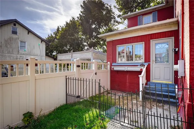 a view of a house with a small yard and wooden fence
