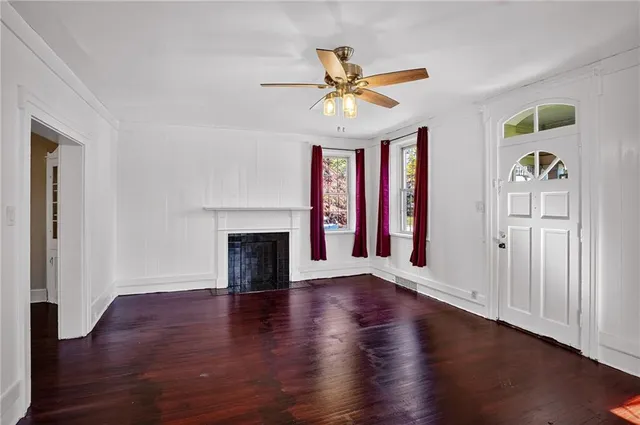 a view of an empty room with window and wooden floor