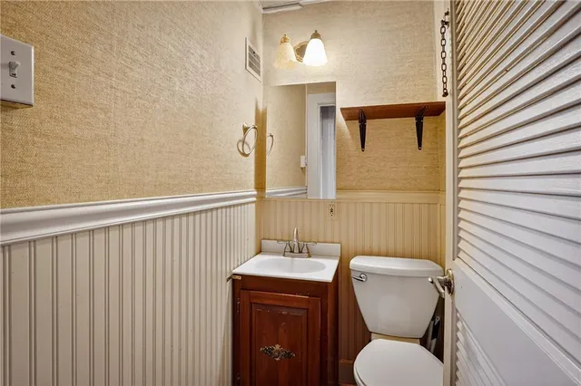 a bathroom with a toilet a sink and mirror