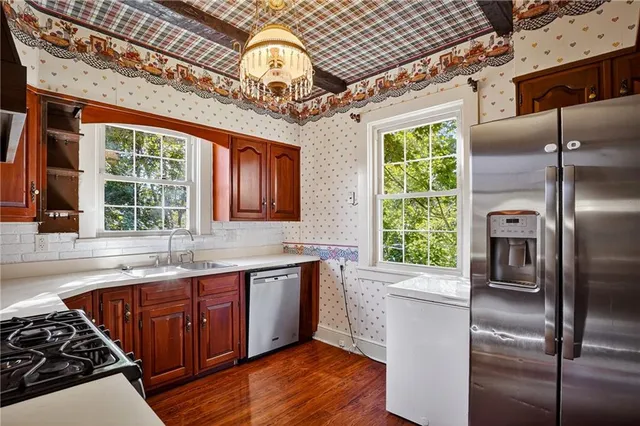 a kitchen with stainless steel appliances granite countertop a sink a stove and a refrigerator