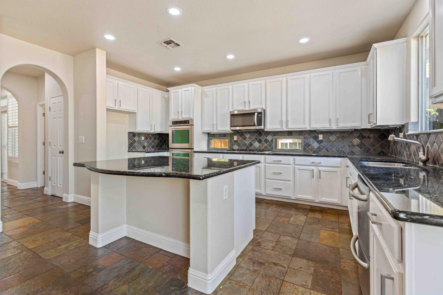 3913 Bayview Drive Modesto, CA 95355 - Photo 11 of 47 a kitchen with stainless steel appliances granite countertop a stove sink and cabinets