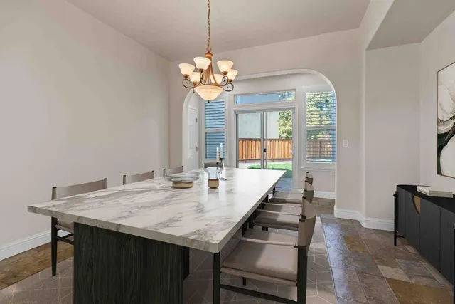 a view of a dining room with furniture a chandelier and wooden floor