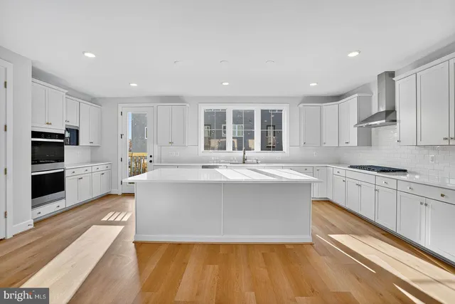 a large kitchen with stainless steel appliances granite countertop a large center island and a stove