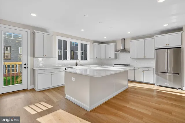 a kitchen with granite countertop a sink stove and refrigerator