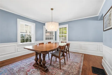 a dining room with furniture a chandelier and wooden floor