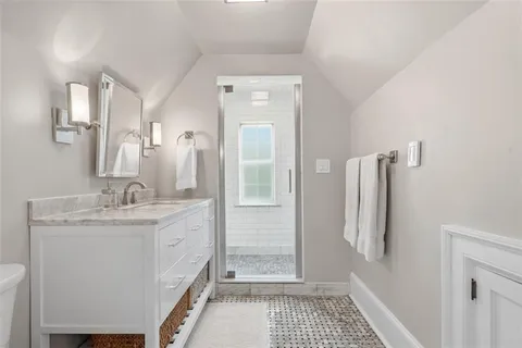 a bathroom with a granite countertop shower a sink and a mirror