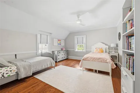 a bedroom with three beds and a book shelf