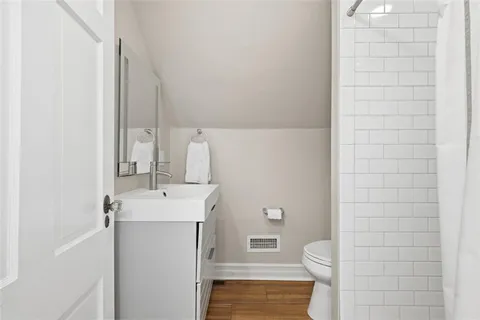 a bathroom with a sink a toilet and shower