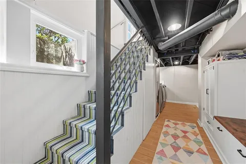 a view of a hallway with wooden floor and staircase