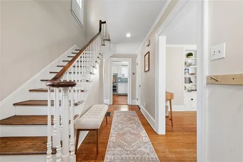 a view of a hallway with wooden floor and staircase
