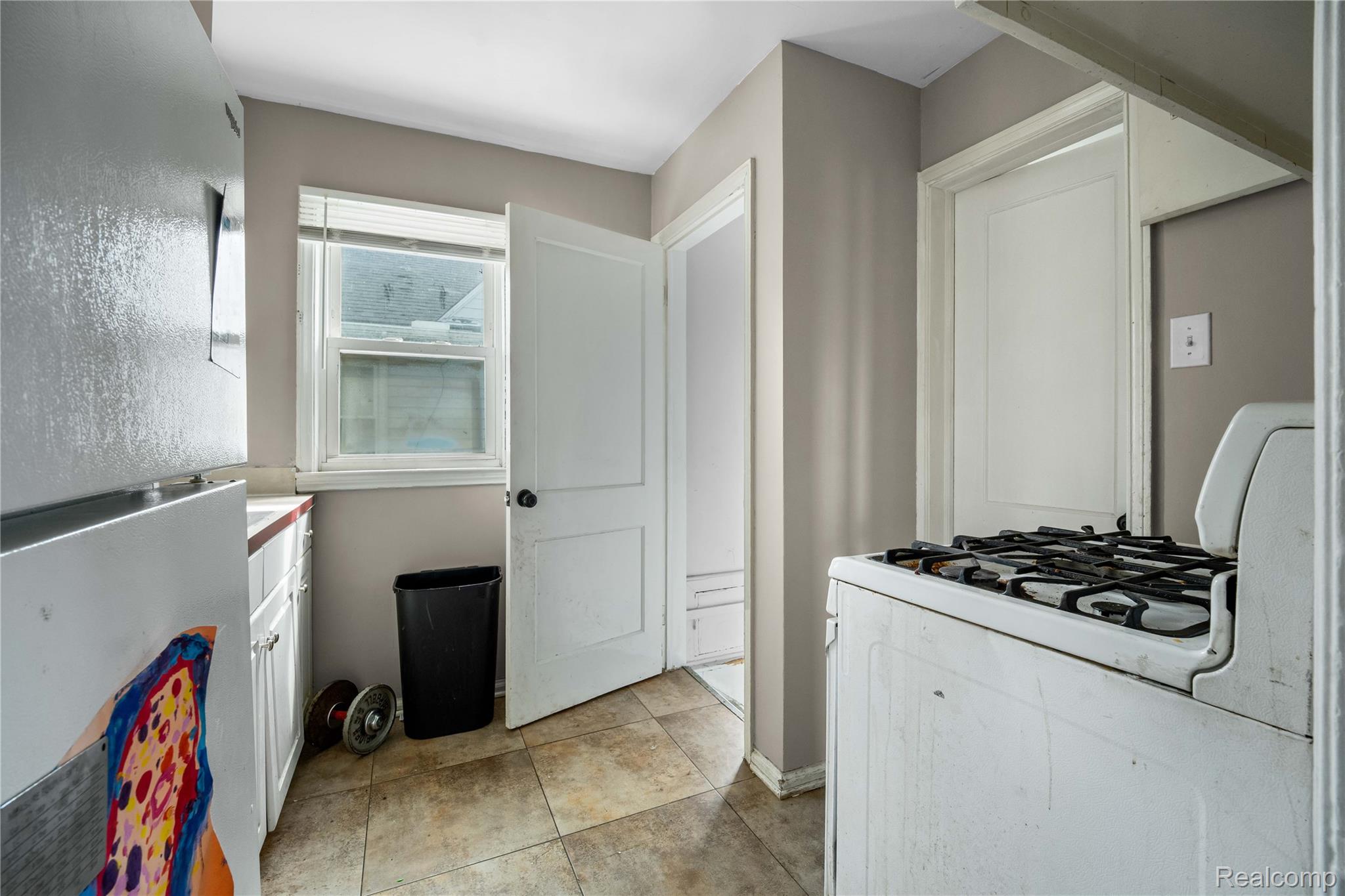 4049 Williams Street Inkster, MI 48141 - Photo 15 of 21 Kitchen featuring freestanding refrigerator, white gas stove, white cabinets, and light countertops
