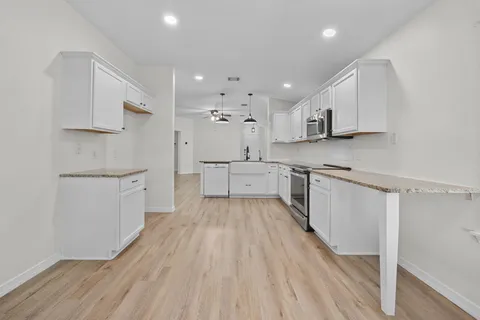 a kitchen with white cabinets and appliances