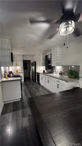 a kitchen with stainless steel appliances kitchen island granite countertop a stove and a sink