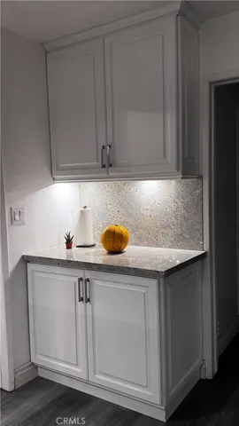 a kitchen with granite countertop white cabinets and sink
