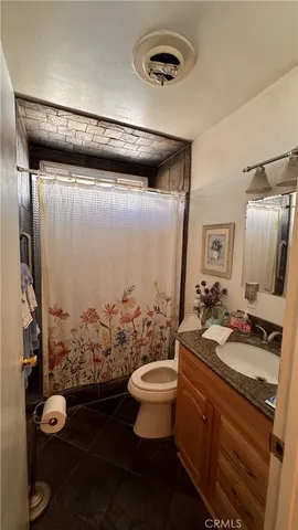 a bathroom with a granite countertop sink a toilet and a mirror