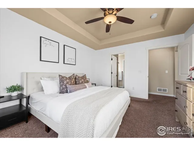 a spacious bedroom with a bed and a chandelier