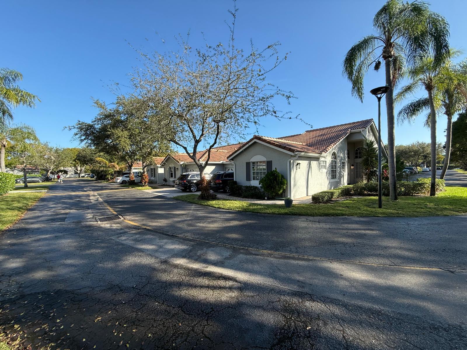 5180 Sabal Gardens Lane, Unit 4 Boca Raton, FL 33487 - Photo 3 of 15 a front view of a house with a yard and garage