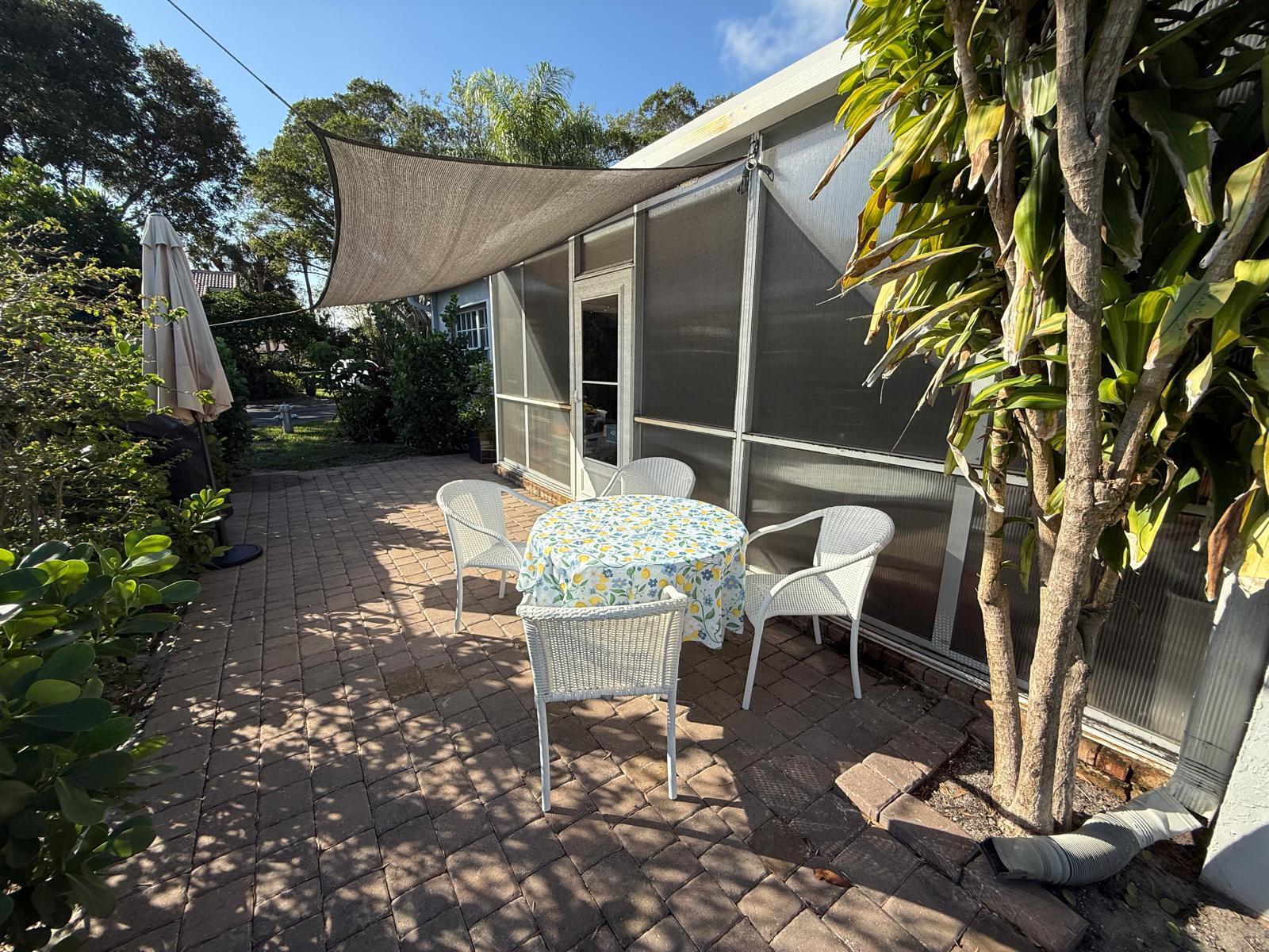 5180 Sabal Gardens Lane, Unit 4 Boca Raton, FL 33487 - Photo 4 of 15 a view of a patio with table and chairs and potted plants