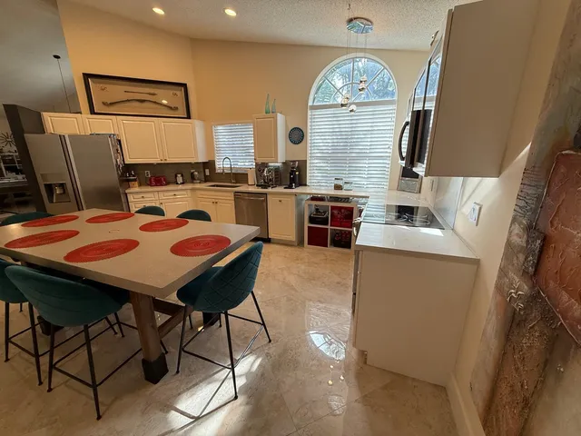 a view of a kitchen with fridge and window