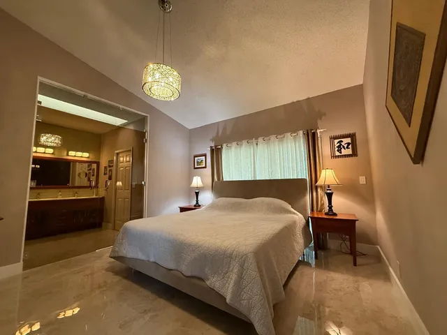 a bedroom with a bed and a chandelier