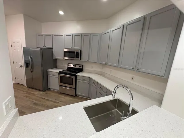 a kitchen with granite countertop a refrigerator and a sink