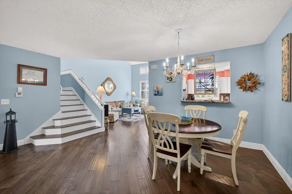 a dining room with furniture a chandelier and wooden floor