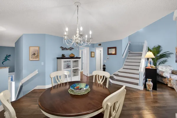 a dining room with furniture a chandelier and wooden floor