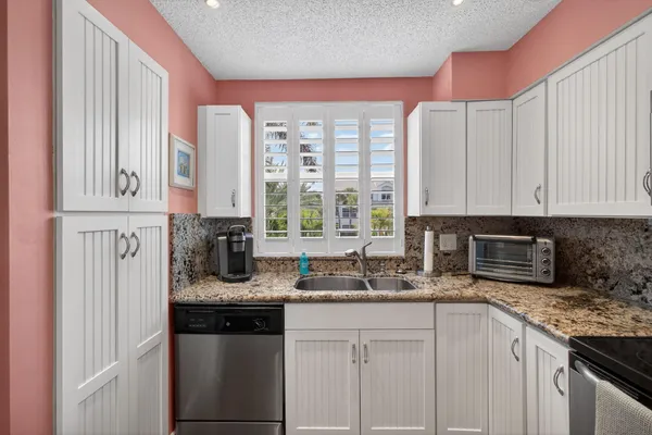 a kitchen with stainless steel appliances granite countertop a sink a stove and a microwave
