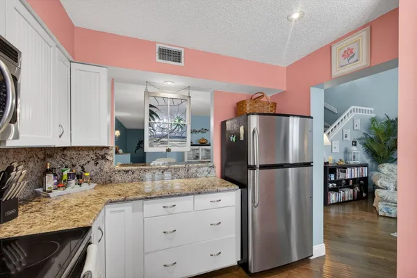 a kitchen with refrigerator a microwave a stove and cabinets