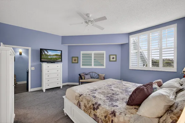 a bedroom with a bed and a ceiling fan