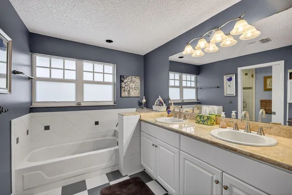 a bathroom with a granite countertop sink mirror and bathtub