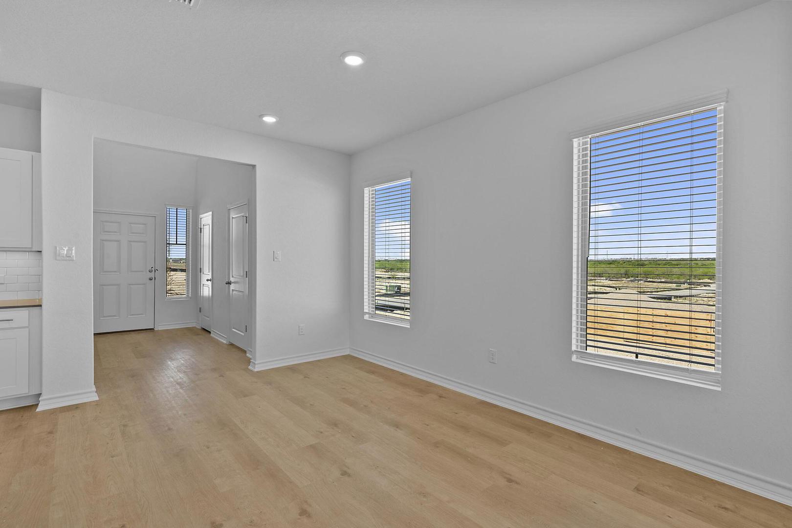Natural light floods this inviting living space, highlighting the beautiful wood flooring and crisp white walls.