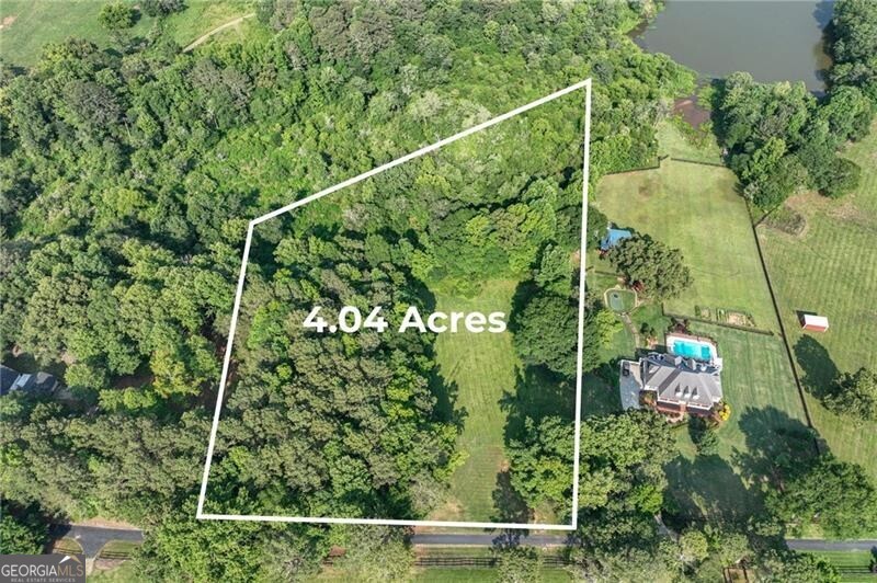 0 Namon Wallace Road Cumming, GA 30028 - Photo 1 of 1 Aerial view of property's location featuring property boundaries highlighted, a heavily wooded area, and a large body of water