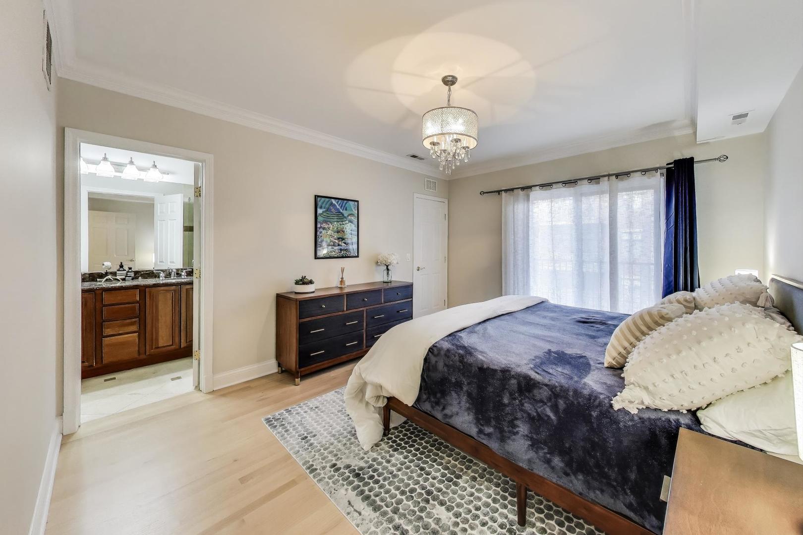 3507 North Reta Avenue, Unit 3 Chicago, IL 60657 - Photo 13 of 24 a spacious bedroom with a large bed and a chandelier