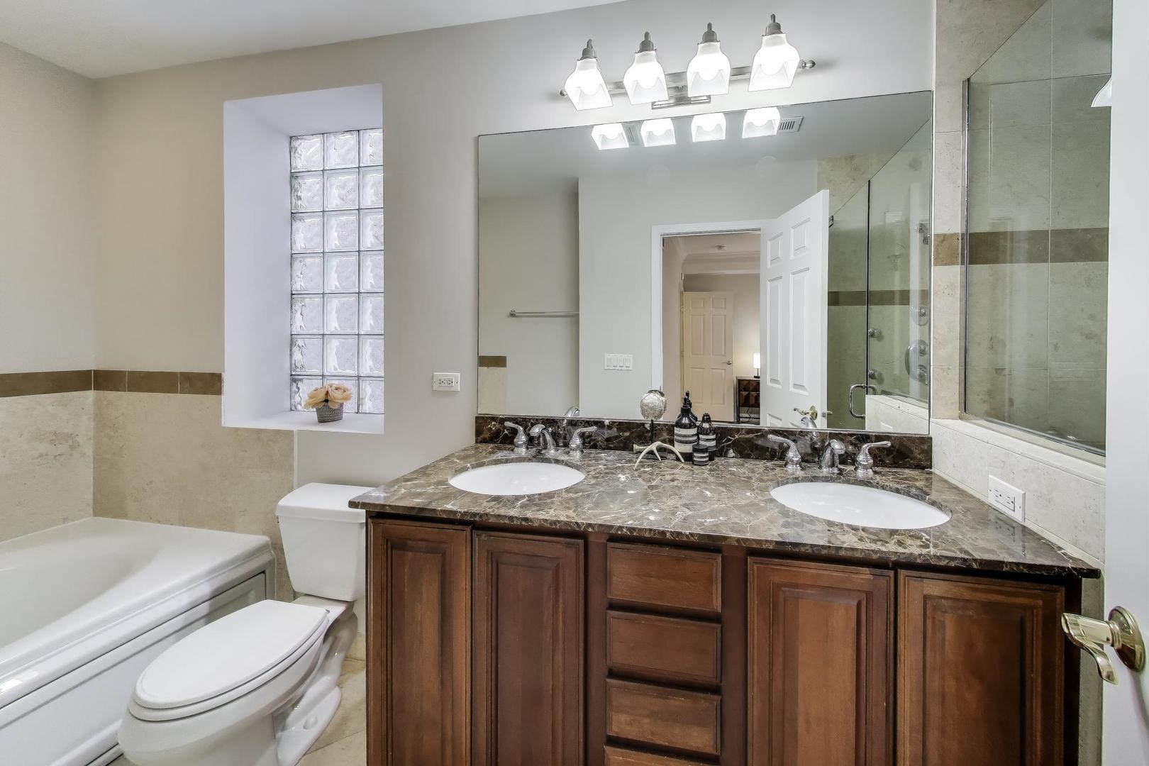 3507 North Reta Avenue, Unit 3 Chicago, IL 60657 - Photo 16 of 24 a bathroom with a granite countertop bathtub sink vanity mirror and toilet
