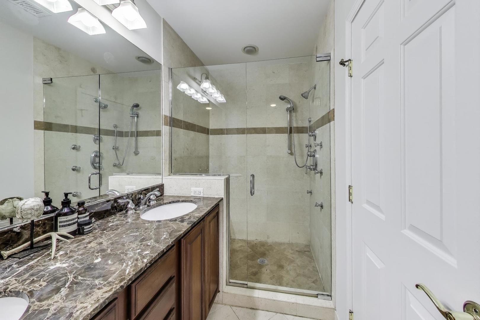 3507 North Reta Avenue, Unit 3 Chicago, IL 60657 - Photo 17 of 24 a bathroom with a granite countertop sink a mirror and shower
