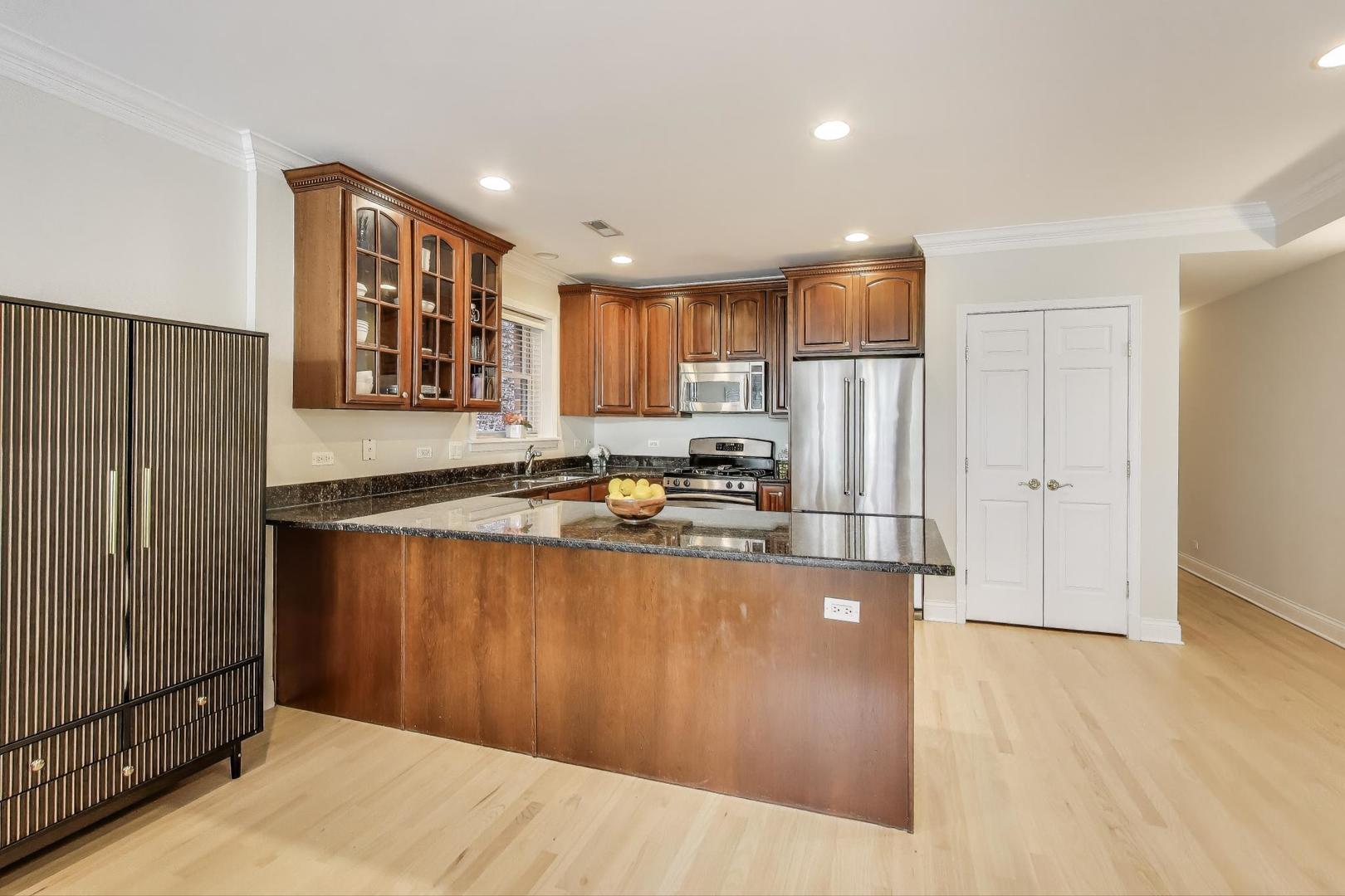 3507 North Reta Avenue, Unit 3 Chicago, IL 60657 - Photo 10 of 24 a kitchen with stainless steel appliances granite countertop a refrigerator a sink a stove and a refrigerator with wooden floor
