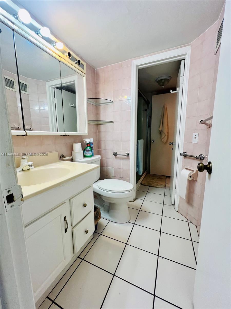 1331 Lincoln Road, Unit 701 Miami Beach, FL 33139 - Photo 9 of 18 a spacious bathroom with a double vanity sink toilet and shower