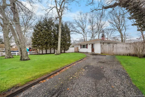 a view of a house with backyard and a tree