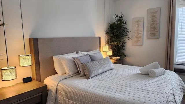 a bedroom with a bed and a potted plant