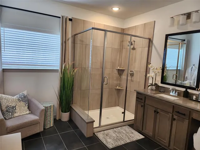 a bathroom with a shower and a sink mirror