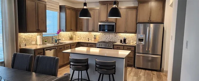 a kitchen with granite countertop a refrigerator and a stove top oven