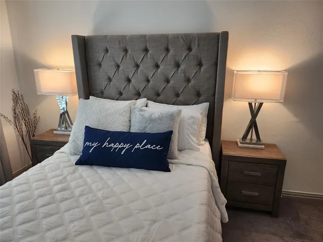 a bed sitting in a bedroom next to a lamp