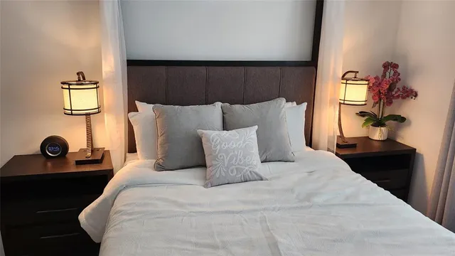 a large bed sitting in a bedroom next to a window