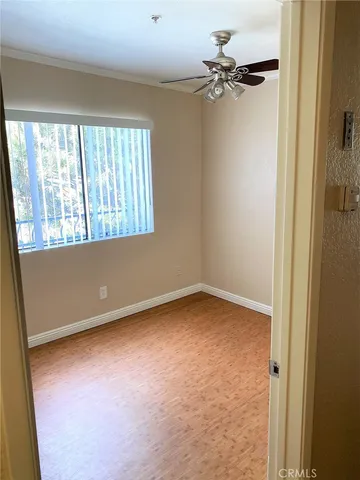 an empty room with a window and a fan