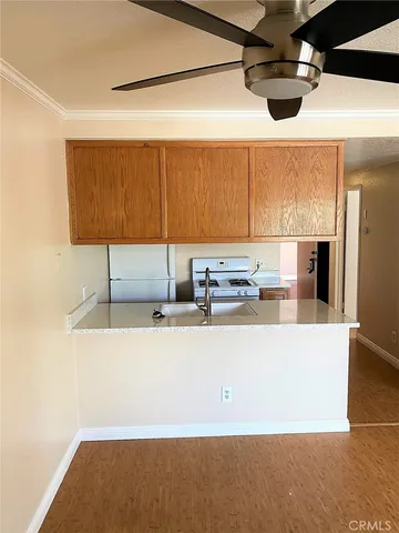 a living room with stainless steel appliances kitchen island granite countertop a sink and a refrigerator